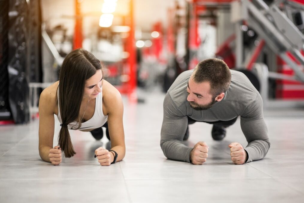 En mann og en kvinne utfører Plank-øvelsen, designet for alle muskelgrupper